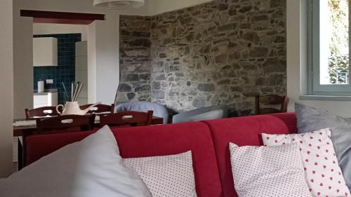 - un salon avec un canapé rouge et des oreillers dans l'établissement Casa Aurelia, Pognana Lario, à Pognana Lario