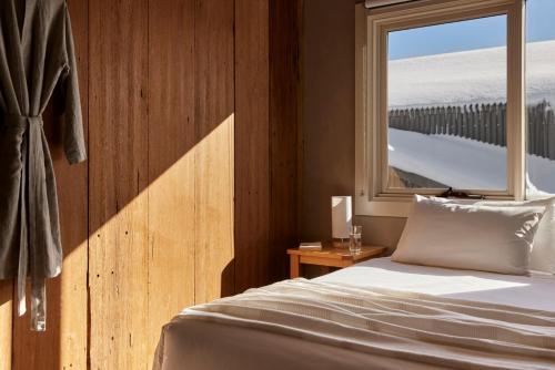 a bedroom with a bed and a window at Lodge Chalet 28 - The Stables Perisher in Perisher Valley