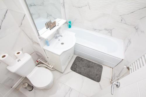 a white bathroom with a toilet and a sink at Sweet Inn in Iaşi