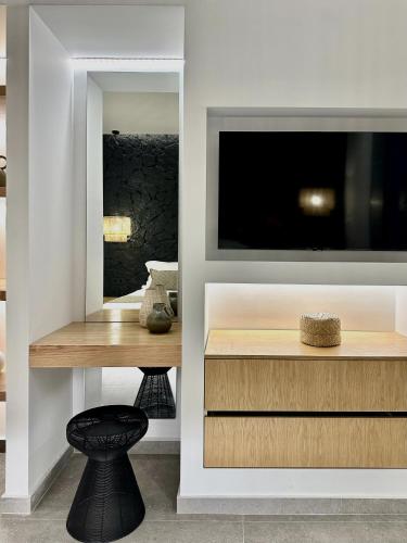 a living room with a television and a stool at Anatelo house in Fira