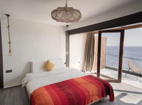 a bedroom with a bed with a view of the ocean at Oceana Surf Camp in Taghazout