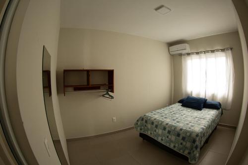 Habitación pequeña con cama y ventana en 5- OHANA - Aloha Bratz Apartments, en Palhoça