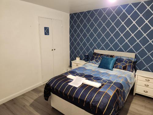 a bedroom with a bed with a blue wall at Gatwick Star Night Stay - Gatwick in Crawley