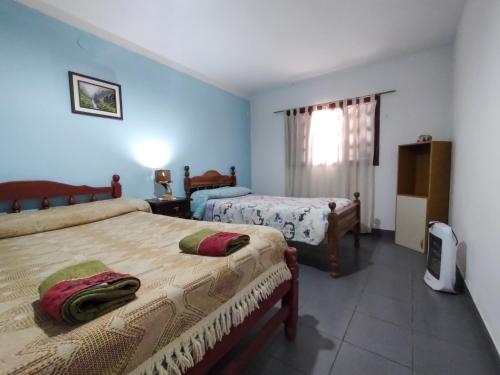 2 camas en una habitación con paredes azules en Casa Uziel en Humahuaca