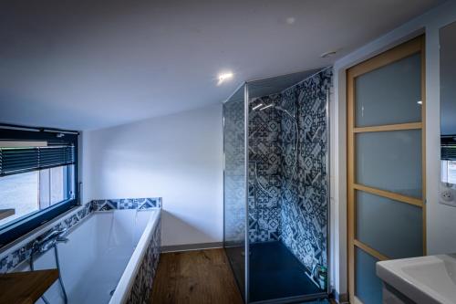 a bathroom with a shower and a glass door at Chalet Luxe et Nature in Anould