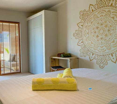a bed with a yellow object on top of it at Isla penthouse & garden apartments Bonaire in Kralendijk