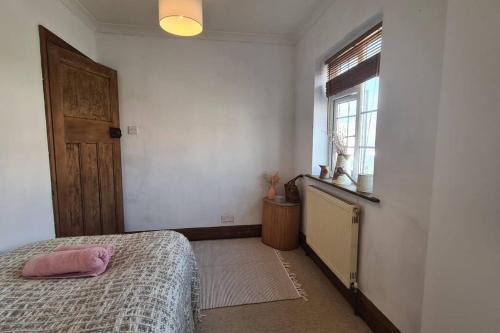 a bedroom with a bed and a window at House on Costal Village free parking in Peacehaven