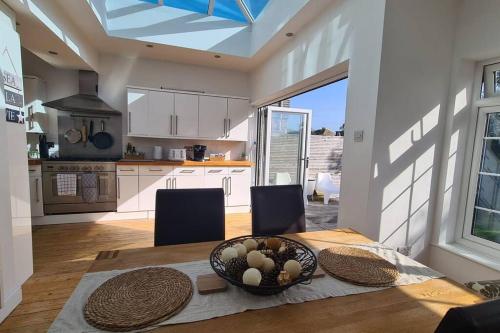 a kitchen with a table with a bowl of food on it at House on Costal Village free parking in Peacehaven