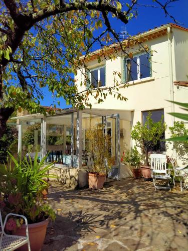une maison avec des portes en verre et une terrasse dans l'établissement LE CITRONNIER, à Lamalou-les-Bains