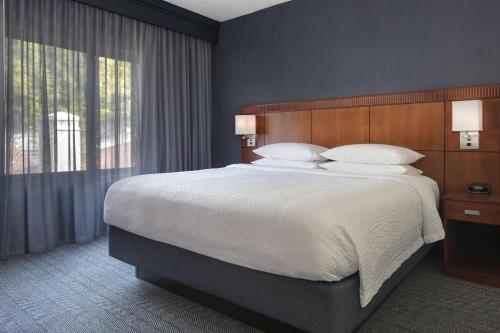 um quarto com uma cama grande e uma janela grande em Courtyard by Marriott Norwalk em Norwalk