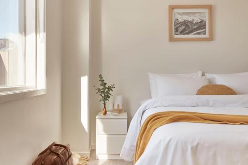 biała sypialnia z łóżkiem i oknem w obiekcie Lodge Apartment 21 The Stables Perisher w mieście Dolina Perisher