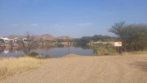 a dirt road next to a body of water at Cozy Stay in Windhoek