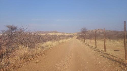 a dirt road in the middle of a field at Cozy Stay in Windhoek