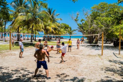 a group of people playing volley ball on a beach at Hotel Rosario de Mar by Tequendama in Isla Grande