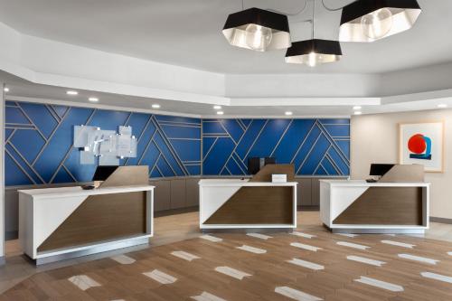 a lobby with two reception desks and a blue wall at Holiday Inn Express Atlanta Airport - North, an IHG Hotel in Atlanta