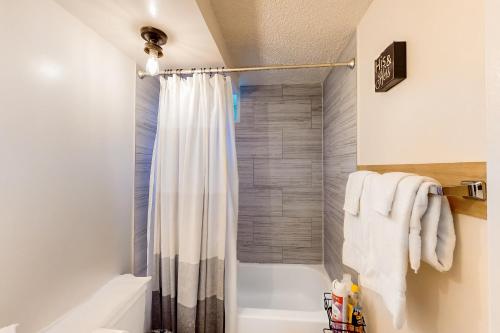 a bathroom with a shower with a shower curtain at The Bamboo Oasis at Bamboo Waikiki #307 in Honolulu