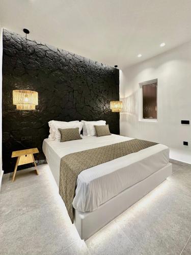 a bedroom with two beds and a stone wall at Anatelo house in Fira