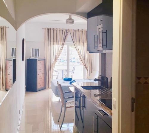 a kitchen with blue cabinets and a table in a room at Lagos Marina view apartment near beaches and shops in Lagos