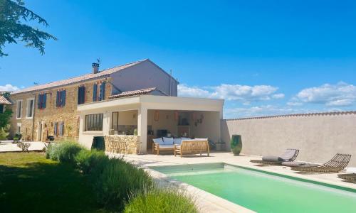 une maison avec une piscine devant une maison dans l'établissement Le Mas Li Jasso, à Piolenc