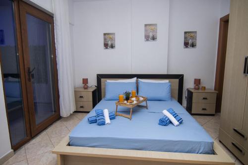 a bedroom with a bed with blue sheets and a table at Amazing Paradise Sensation 2 Bedroom Luxury Apartment with a Jacuzzi in Durrës