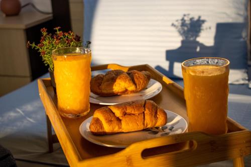 a tray with two plates of bread and two glasses of orange juice at Amazing Paradise Sensation 2 Bedroom Luxury Apartment with a Jacuzzi in Durrës
