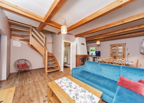 a living room with a blue couch and a spiral staircase at Willa Hrobacza spa in Międzybrodzie Bialskie