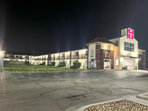 an empty parking lot in front of a building at night at Countryside Suites Kansas City Independence I-70 East Sports Complex Hotel in Independence