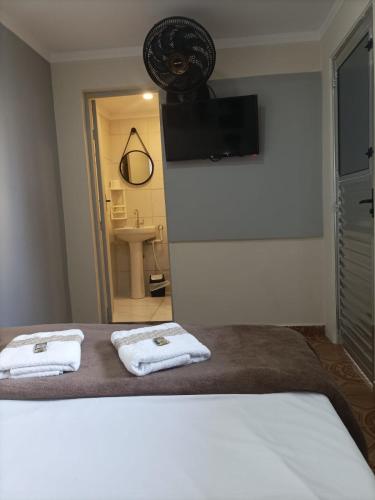 a bedroom with two towels on a bed at Lá Casa do Manguinha in Guarulhos