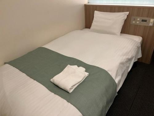 a bed with a white towel sitting on it at Hotel Shinjukuya - Vacation STAY 74722v in Machida