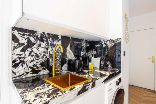 eine Küche mit gelbem Waschbecken und schwarzweißer Tapete in der Unterkunft Amazing appartement - 8P - Le Bon Marché in Paris