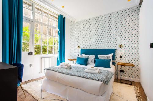 ein Schlafzimmer mit einem großen Bett mit blauen Akzenten in der Unterkunft Amazing appartement - 8P - Le Bon Marché in Paris