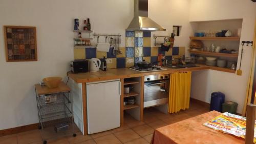 - une petite cuisine avec un comptoir et une cuisinière dans l'établissement Gîte Périssé, à Libaros