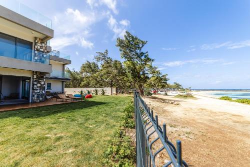 uma casa com uma cerca ao lado da praia em Ocean Terraces Apt A1 - Your Beachfront Bliss - Brand NEW em Poste Lafayette