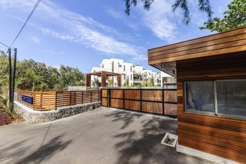 a house with a wooden fence next to a driveway at Ocean Terraces Apt A1 - Your Beachfront Bliss - Brand NEW in Poste Lafayette