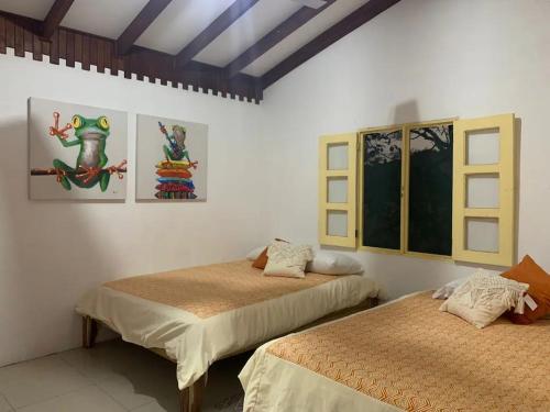 - une chambre avec 2 lits et des peintures murales dans l'établissement Villas La Paillote Costa Rica, à Puntarenas