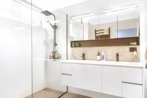 a white bathroom with a sink and a shower at Best Value With City View Sleeps 7 in Brisbane