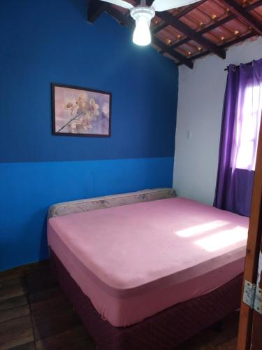 - une chambre avec un lit dans une pièce bleue dans l'établissement Linda kitinet, à Cabo Frio
