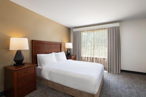 a bedroom with a large bed and a window at Residence Inn Beaumont in Beaumont