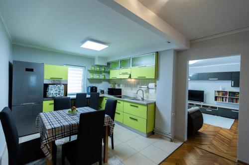 uma cozinha e sala de jantar com armários amarelos e uma mesa em Lara's Residence em Timisoara