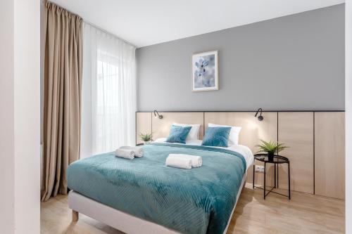 sypialnia z dużym łóżkiem z ręcznikami w obiekcie Warsaw City Apartments Stadion Narodowy w Warszawie