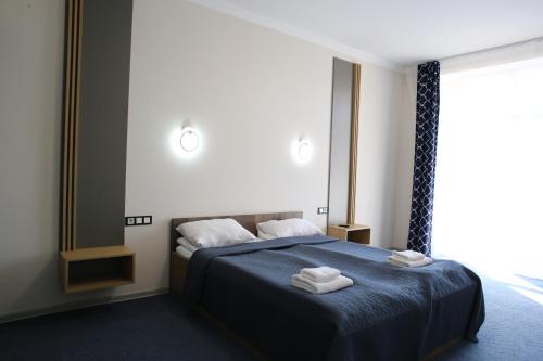 a bedroom with a blue bed with towels on it at RIVER SIDE in Polyana
