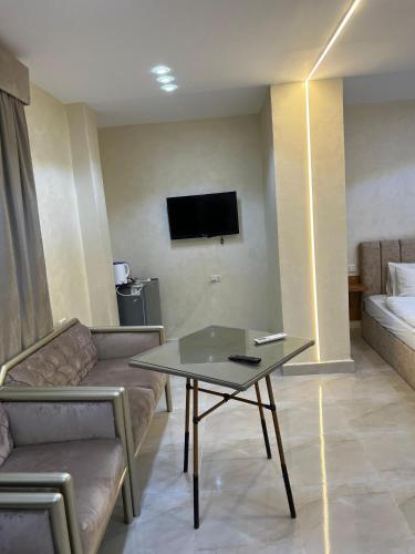 a living room with a couch and a table and a tv at Pyramids Height Hotel & Pyramids Master Scene Rooftop in Cairo