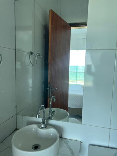 a bathroom with a sink and a mirror at Pousada Diana Maragogi in Maragogi