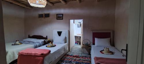sypialnia z 2 łóżkami i lustrem w obiekcie Maroc des Merveilles - Chez L'habitant w mieście Kalaat M'Gouna