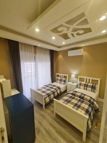 1 dormitorio con 2 camas y mesa azul en شقة فخمة باطلالة جذابة, en Irbid