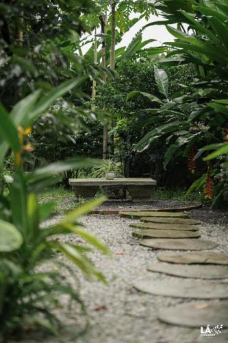 a stone path with two benches in a park at Thom's House in Ninh Binh