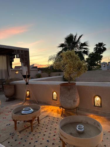 Sala de estar con 2 mesas de centro y puesta de sol en Riad des Fragrances dar el Bacha en Marrakech