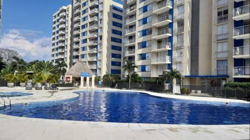 uma piscina em frente a alguns edifícios de apartamentos em Puerto Azul- Club House. em Ricaurte