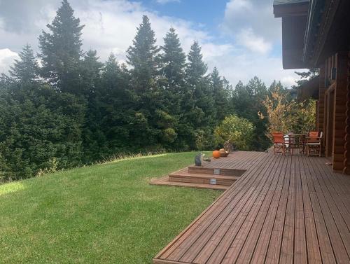 a wooden deck with tables and chairs on a yard at The Flysch in Miríki