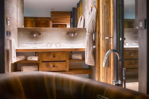 ein Badezimmer mit zwei Waschbecken und Holzschränken in der Unterkunft Luxueux Penthouse avec SPA privé - Cap Crystal Lodge in Tignes